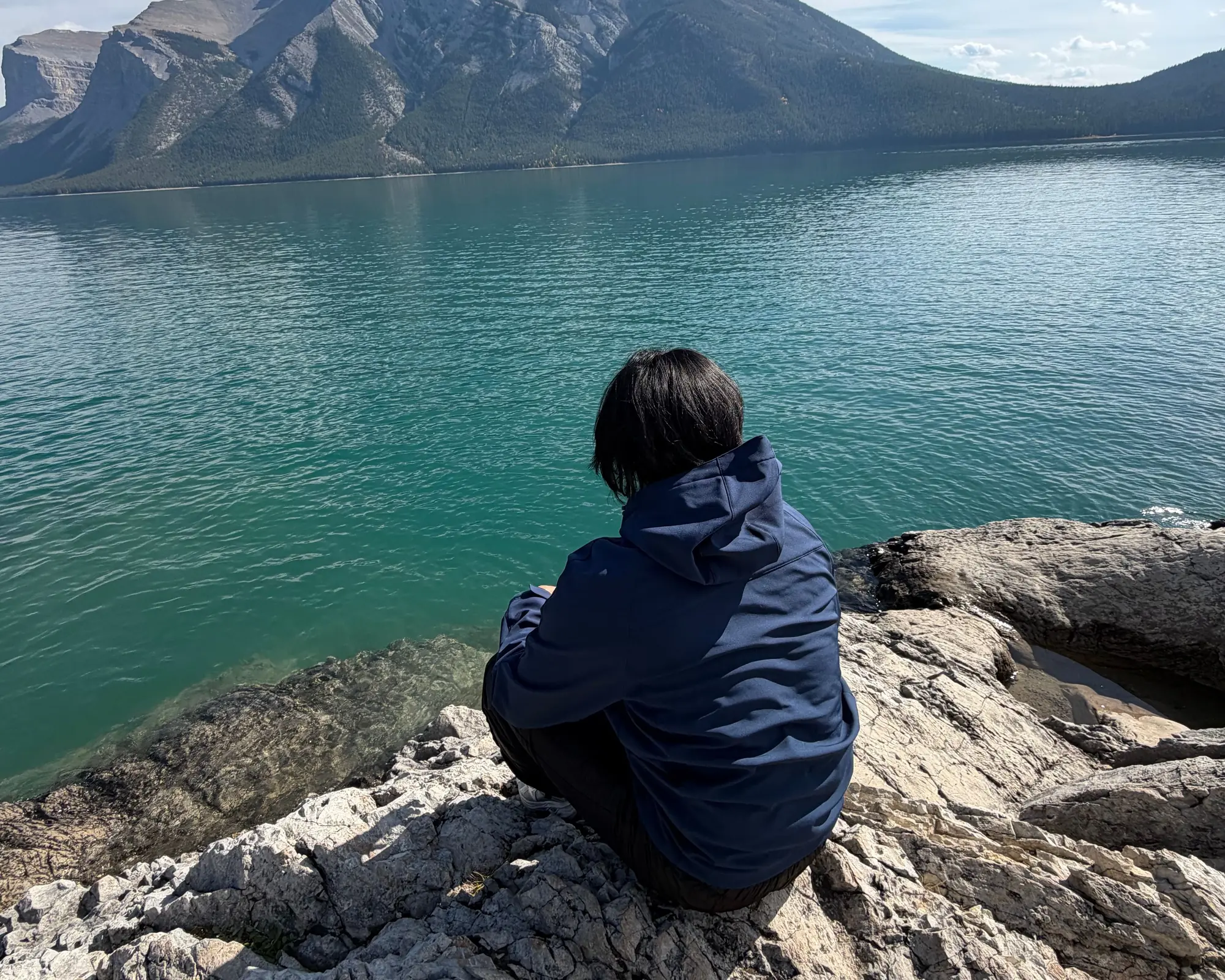 Matthew sitting on the rocks by a lake in Banff